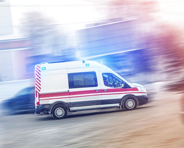 Ambulance racing through city traffic jam on slippery road with slush snow. Car accident on highway